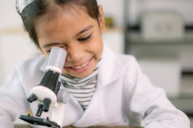 Asyalı kız öğrenci, test tüpü ile fen kimyası öğreniyor. Laboratuvarda deney yapıyor. Eğitim, bilim, kimya ve çocuk kavramları. Çocukların erken gelişimi.