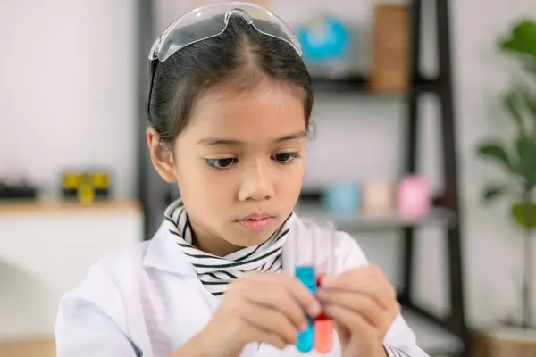 Asian child girl learning science chemistry with test tube making experiment at school laboratory. education, science, chemistry, and children\'s concepts. Early development of children.