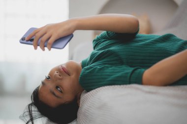 Asyalı genç kızlar evde cep telefonu kullanıyor.