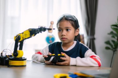 Asyalı kızlar robot programlama öğreniyor ve robot kolları üzerinde ders kontrolü yapıyorlardı. Laboratuvar. Matematik, mühendislik, bilim, teknoloji, bilgisayar kodu, kodlama. STEM eğitimi.