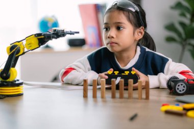 Asyalı kızlar robot programlama öğreniyor ve robot kolları üzerinde ders kontrolü yapıyorlardı. Laboratuvar. Matematik, mühendislik, bilim, teknoloji, bilgisayar kodu, kodlama. STEM eğitimi.