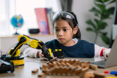 Asyalı kızlar robot programlama öğreniyor ve robot kolları üzerinde ders kontrolü yapıyorlardı. Laboratuvar. Matematik, mühendislik, bilim, teknoloji, bilgisayar kodu, kodlama. STEM eğitimi.