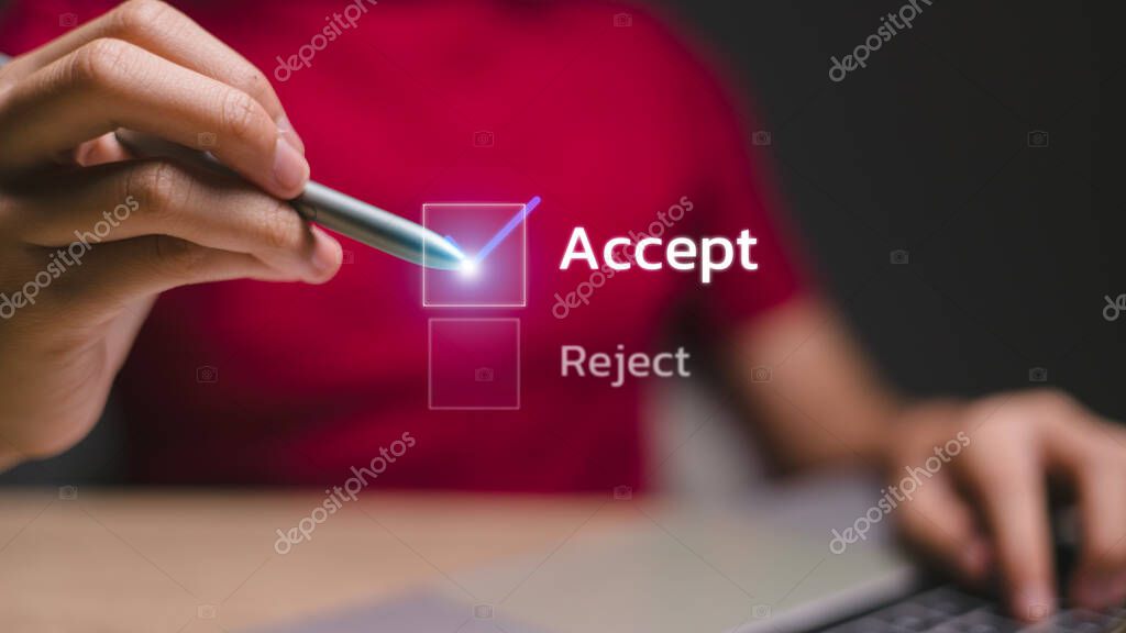 A person is holding a pen and writing the word 