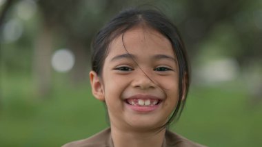 Yüzünde bir gülümseme olan genç bir kız. Bir kaç dişi eksik. Masumiyet ve mutluluk kavramı