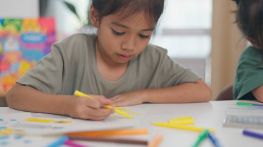 İki çocuk su ve temiz bir konteynırla ilgili bir bilim deneyiyle oynuyorlar. İkisi de deneye odaklanmış ve eğleniyor gibi görünüyorlar.