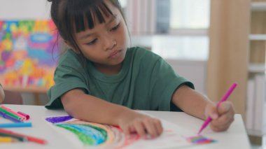 İki çocuk su ve temiz bir konteynırla ilgili bir bilim deneyiyle oynuyorlar. İkisi de deneye odaklanmış ve eğleniyor gibi görünüyorlar.