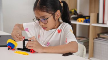 BTMM eğitim konsepti. Asyalı ev okulu kızları internetten ders alıyorlar ve BTMM oyuncakları yapmak için heyecanlılar. Çocukların kavramları için matematik mühendisliği bilgisayar kodu..