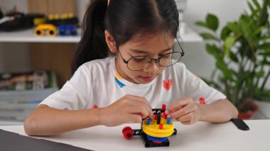 BTMM eğitim konsepti. Asyalı ev okulu kızları internetten ders alıyorlar ve BTMM oyuncakları yapmak için heyecanlılar. Çocukların kavramları için matematik mühendisliği bilgisayar kodu..