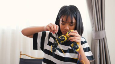 Asyalı kız evde robot kolu monte ediyor. BTMM eğitimini, kodlamayı, mühendisliği ve problem çözme becerilerini teşvik etmek. Geleceğin yenilikçileri ve genç mühendisleri için teknolojik eğitim..