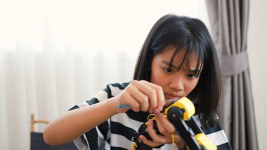 Asyalı kız evde robot kolu monte ediyor. BTMM eğitimini, kodlamayı, mühendisliği ve problem çözme becerilerini teşvik etmek. Geleceğin yenilikçileri ve genç mühendisleri için teknolojik eğitim..