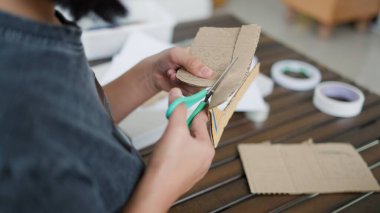 Evde yaratıcı DIY aktivitesi yapan Asyalı kızlar sanat malzemeleri, makas ve konsantrasyonla evde eğitim ortamında beceri ve hayal gücü geliştiriyorlar..