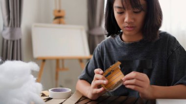 Evde yaratıcı DIY aktivitesi yapan Asyalı kızlar sanat malzemeleri, makas ve konsantrasyonla evde eğitim ortamında beceri ve hayal gücü geliştiriyorlar..