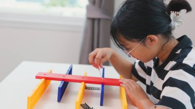 Asyalı kız, BTMM öğrenme etkinliğinin bir parçası olarak renkli bir plastik yapıyı tornavidayla birleştiriyor. Elle eğitim, çocuk mühendisliği, yaratıcılık ve sorun çözme kavramı.