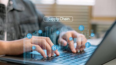 İş adamları sanal tedarik zinciri simgeleri içeren, lojistik, envanter yönetimi, tedarik, ulaşım, depo otomasyonu ve dijital tedarik zinciri dönüşümünü sembolize eden bir dizüstü bilgisayar kullanıyorlar..