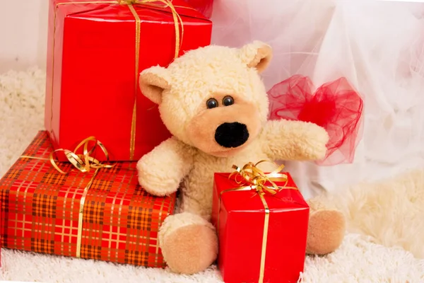 Boxes with gifts and a teddy bear toy.