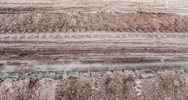 Sandy Field Road with Deep Tire Tracks from a Large Vehicle. Construction Sand or Gravel
