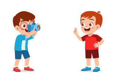 Küçük çocuk kamerayı tutuyor ve arkadaşının fotoğrafını çekiyor.