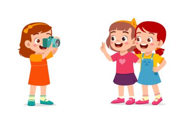 Küçük çocuk kamerayı tutuyor ve arkadaşının fotoğrafını çekiyor.