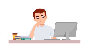 Adam çalışan masa başında oturup ofiste çalışıyor ve bilgisayara ciddi bakıyor.