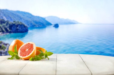 Egzotik deniz altyapısı olan beyaz ahşap tahtada ikiye kesilmiş taze greyfurtlar. Foo, içki ve ürünler için yer kopyala. Sıcak yaz mevsimi ve güneş ışığı.