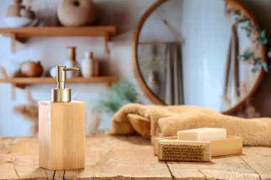 Masada sabun ve aksesuarlı kompozisyon. Ürünler ve metinler için alan. Banyo dolabının ahşap tezgahında yıkanmak için kullanılan hijyen aksesuarları ve sıcak bir banyonun duvarında ayna.