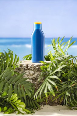 Plajda bir şişe güneş kremi. Güneş koruması. Ağaç gövdesine güneş kremi sür ve ürünler için yer kopyala.
