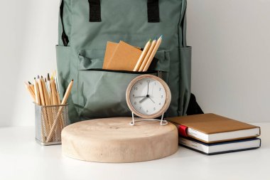 Renk duvarına karşı açık ahşap masa üzerinde kitap ve kırtasiye malzemesi olan kompozisyon. Metin ve ürün için boşluk.