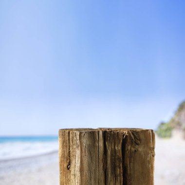 Ürünler ve nesneler için kopyalama alanı olan boş ağaç kütüğünü masa arkaplanı olarak kullanın. Deniz ve tropik plaj arka planı.