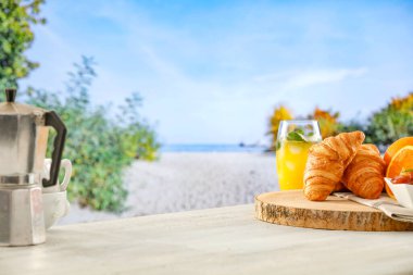 Plajda yaz kahvaltısı. Kruvasan, reçel ve meyve. Montaj ürün gösterimi için yaz tablosu arka planı. Yiyecek, içecek ve ürünler için boşluk kopyala.