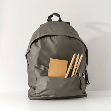 Beyaz arkaplan üzerinde okul kırtasiyesi olan sırt çantası