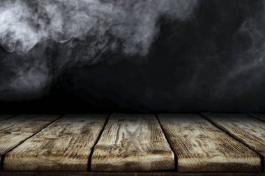 Dumanlı karanlık soyut oda, ahşap masa ve dumanlı siyah duvar. Ürün ve aksesuarlar için alanı kopyala.