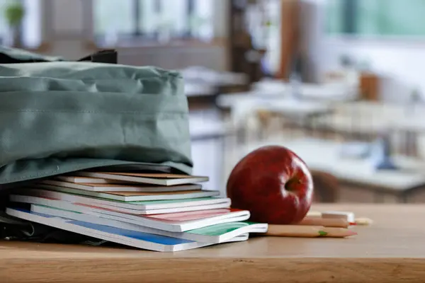 stock image Wooden desk with school suppies in the classroom. Copy space for products.