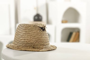 Yazlık eşyalar, hasır şapka ve hasır çanta yuvarlak beyaz masa üzerinde fotokopi alanı ile modern minimalist parlak iç mekan.
