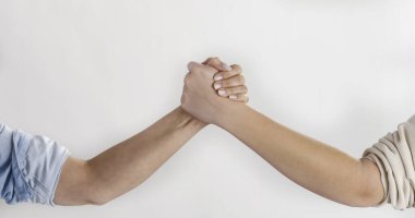 Genç ve olgun kadınlar arasındaki güçlü el sıkışma, destek kavramı, rekabet ve nesiller arası bağlantı, güçlü kavrama sembolü, birlik ve rekabet.