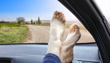 Erkek bacakları arabanın içinde.