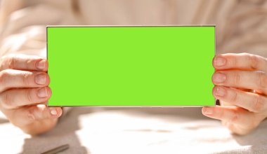 Kadının elinde boş yeşil akıllı telefon ekranı. Metin için alanı kopyala.