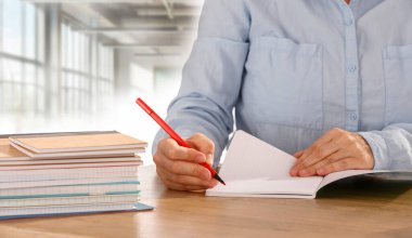 Not defterine not yazan kadınların ellerini kapat. Ofis geçmişi bulanık. Metin ve ürün için alanı kopyala. 