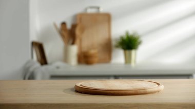 Fotokopi alanı olan boş ahşap masa ve bulanık mutfak arka planı.