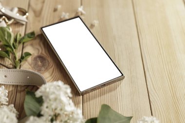 Bahar çiçekleri, cep telefonu ve kadın çantası. Anneler Günü için mükemmel bir tasarım. Metin veya ürün için akıllı telefon ekran kopyalama alanı.