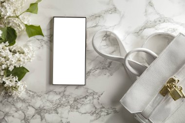 Anneler Günü ya da düğün dairesi eflatun çiçekleri ve beyaz mermer arka planda beyaz bir çantayla yatıyordu. Yazı ya da ürün için boş fotokopi alanı olan romantik bir kompozisyon. Tasarım projesi için mükemmel.