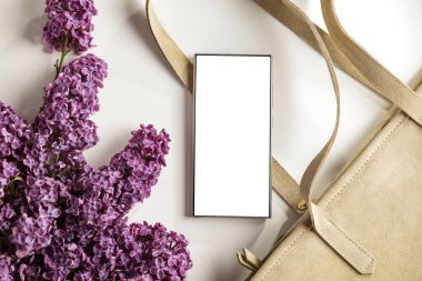 Bahar kompozisyonu içinde leylaklarla fotokopi alanı olan boş ekran cep telefonu. Düz konum ve beyaz arkaplan modeli.