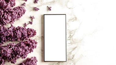 Boş ekran cep telefonu. İlkbahar kompozisyonu ve mermer yüzeyinde leylaklar var. Düz konum ve beyaz arkaplan modeli.