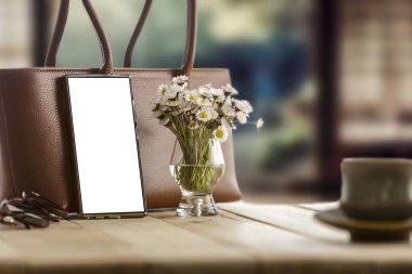 Şık bahar kompozisyonu, papatya çiçekleri ve ahşap masa üzerinde kadın çantası ve bulanık pencere örtüsü..