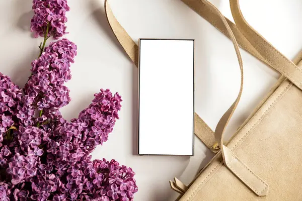 Bahar kompozisyonu içinde leylaklarla fotokopi alanı olan boş ekran cep telefonu. Düz konum ve beyaz arkaplan modeli.