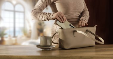 Masa başı sabah rutininde kadın el çantası paketleme çantası. Boşluk ve iş hayatı, üretkenlik, evden çalışma veya günlük rutin kavramları kopyala.