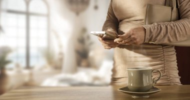 Sabah Rutinini El Çantası ve Kahveyle Bırakmadan Önce Telefonu Kontrol Eden Kadın. Günlük Yaşam Tarzı Sahnesine Çıkmadan Önce Akıllı Telefon Kullanıyor.