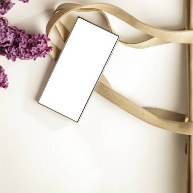 Metin veya ürün için kopyalama alanı olan ahşap bir masanın üzerinde düz bir akıllı telefon yatıyordu. Moda, kozmetik, yaşam tarzı proje tasarımları veya ürün yerleştirme temaları için mükemmel