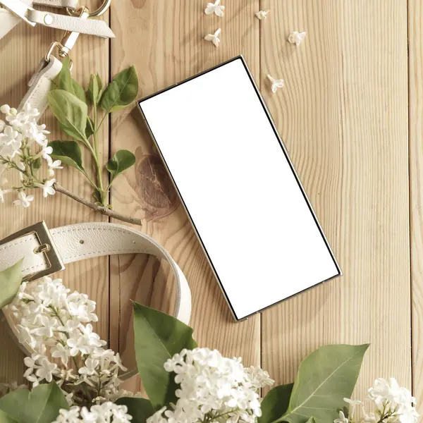 Metin veya ürün için kopyalama alanı olan ahşap bir masanın üzerinde düz bir akıllı telefon yatıyordu. Moda, kozmetik, yaşam tarzı proje tasarımları veya ürün yerleştirme temaları için mükemmel