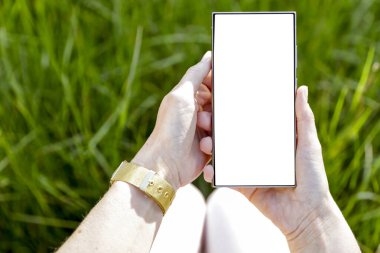 Doğal yeşil yeşillik bahçesi arka planı ve doğal gün ışığı için metin alanı olan boş ekranlı akıllı telefon.