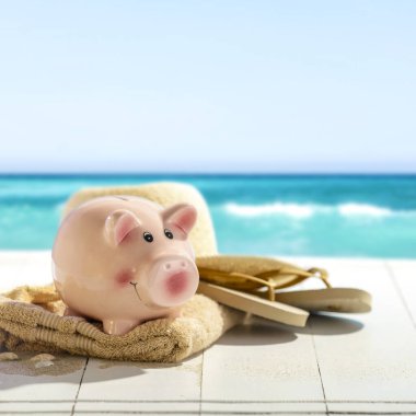 Deniz kıyısındaki güvertede tatil bütçesi domuz kumbarası. Kopyalama alanı ve tatil tasarrufu, tatil planlaması, yaz finansmanı veya seyahat için kişisel bütçe. 
